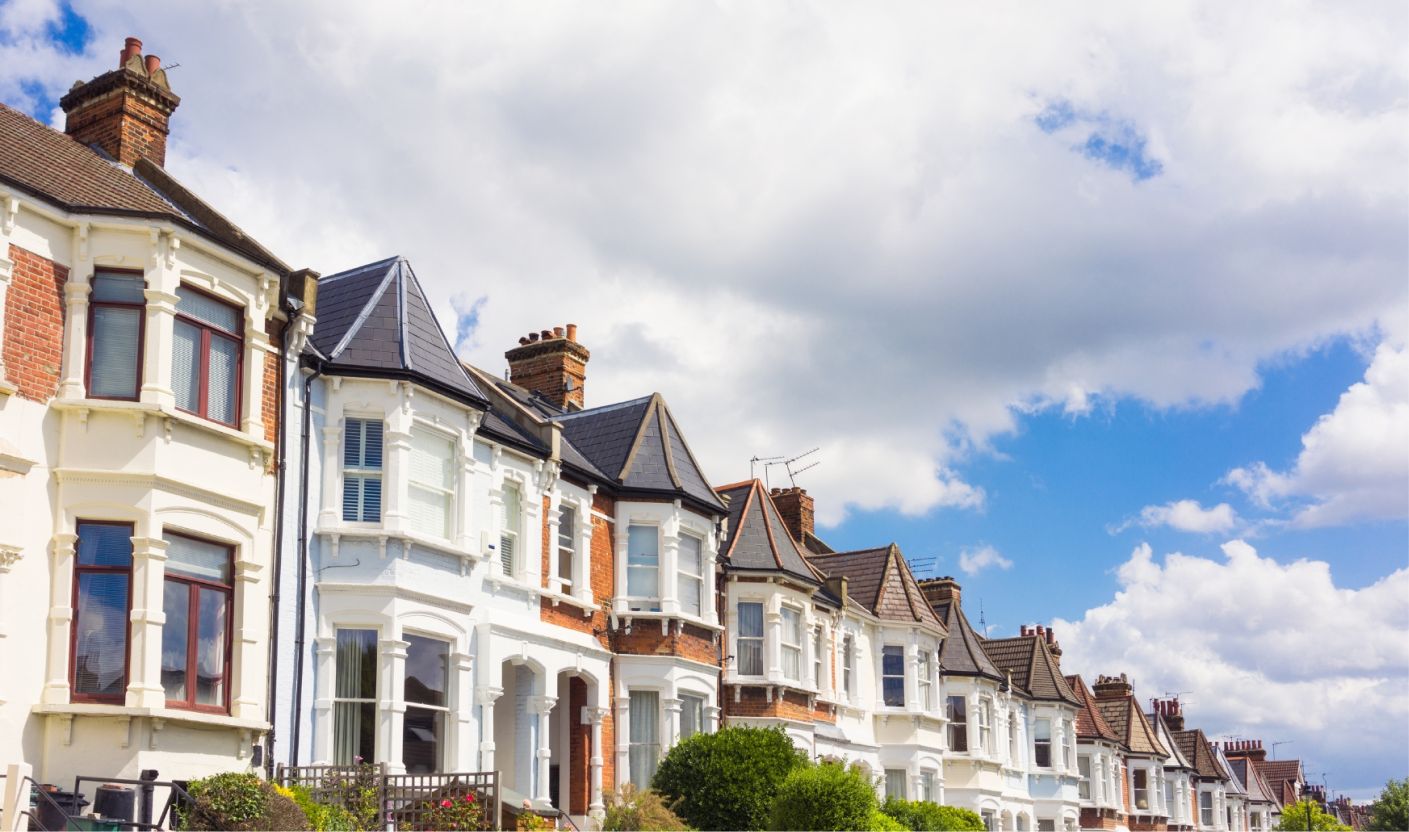 A row of terraced homes in the UK under a blue sky