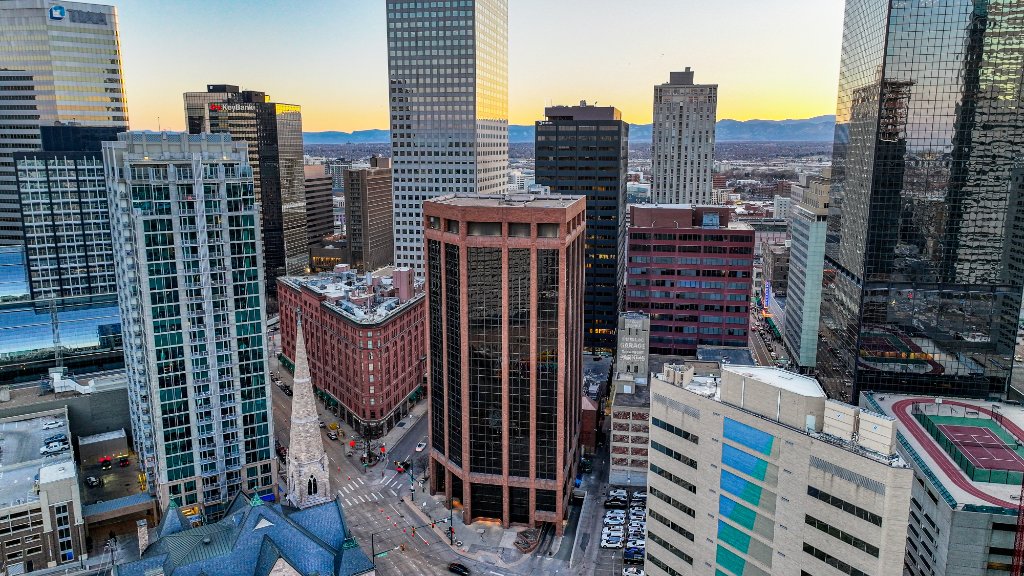 Twilight Aerial — Trinity Place Lit Against Sunset Skyline