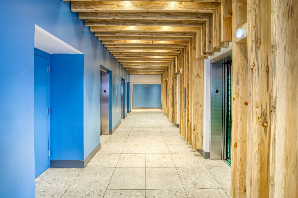 Lobby — Elevator Bank & Wood Beam Corridor
