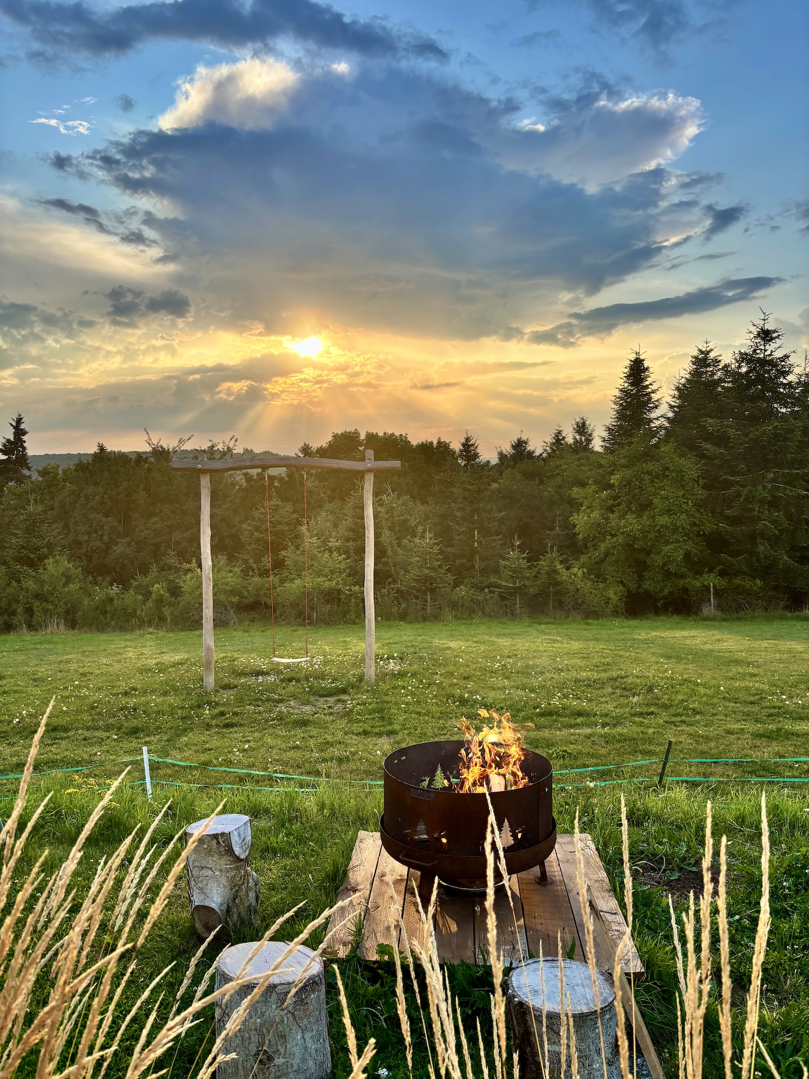 Lagerfeuer und Sonnenuntergangsschaukel auf der Terrasse