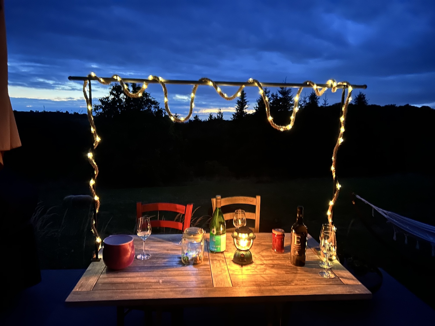 Gedeckter Tisch vor einer Ferienwohnung in der Dämmerung – authentische Aufnahme