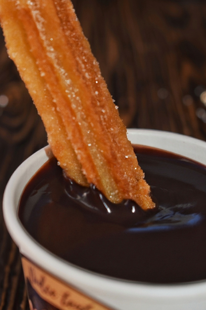 Puesto artesanal de churros con luces cálidas en un evento al aire libre