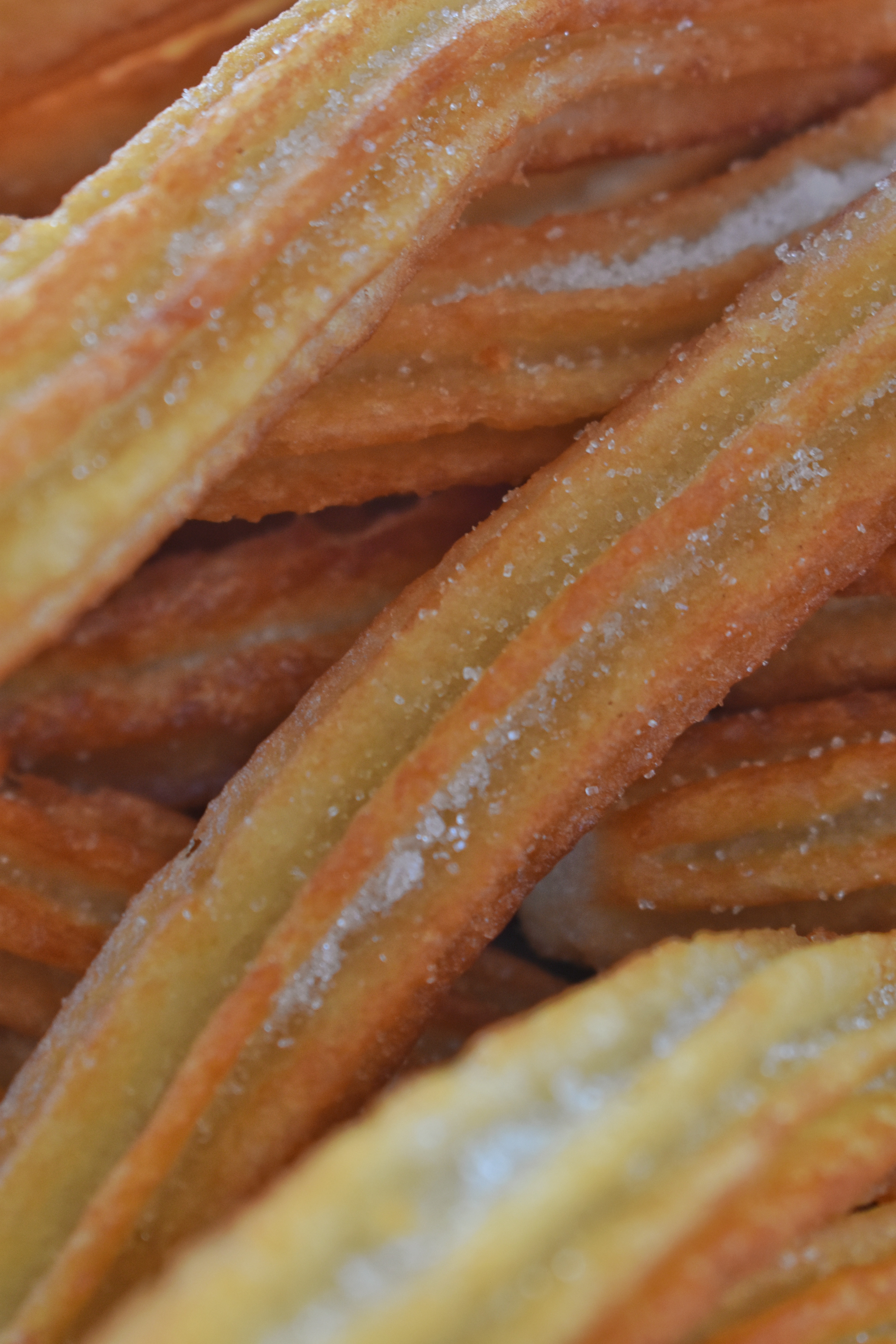 Primer plano de churros recién hechos dorados y azucarados