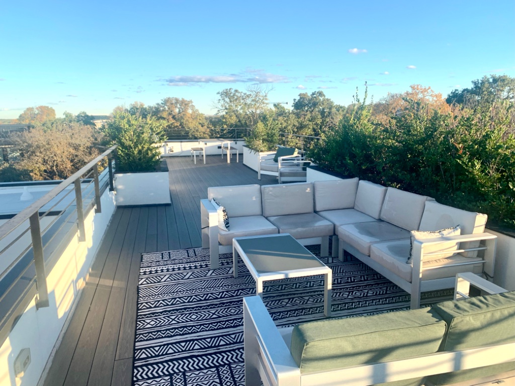 Rooftop seating area with lush greenery surroundings