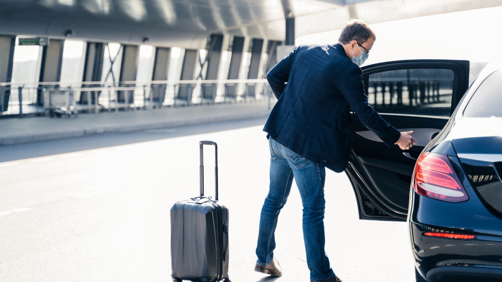 Man With Suitcase Getting Into Car. Real photograph by vkstudio, sourced through Canva. Illustrative stock photo; not a photograph of the venues or services reviewed.