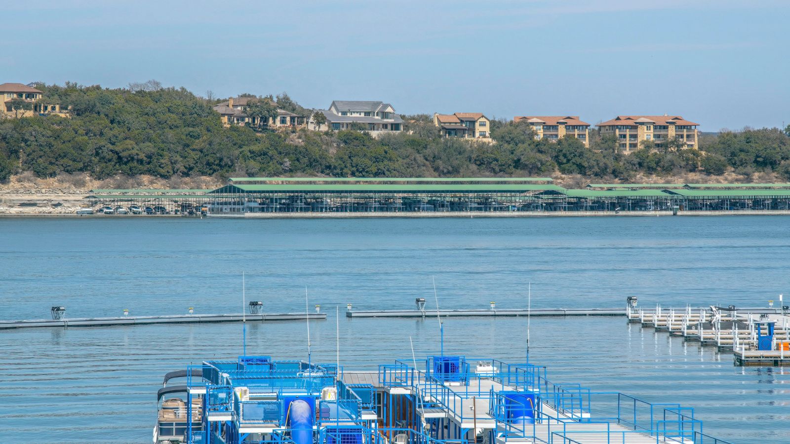 Flat party boats on a dock at Lake Austin, Austin, Texas. Real photograph by Jason Finn / Getty Images, sourced through Canva.