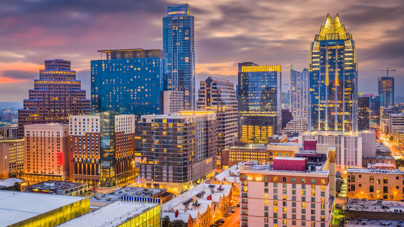 Downtown Austin at dusk with the Frost Bank Tower and illuminated streets. Photograph by Sean Pavone / Getty Images Pro, sourced through Canva.