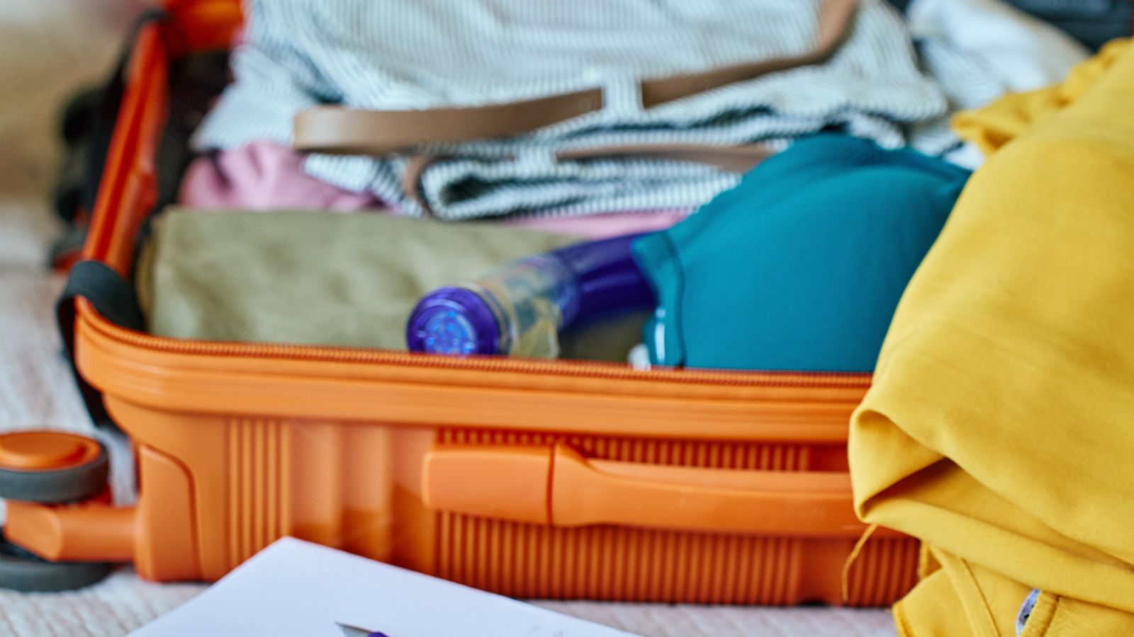 Woman packing suitcase and writing travel checklist. Real photograph by aliaksandrbarysenka, sourced through Canva. Illustrative stock photo; not a photograph of the venues or services reviewed.