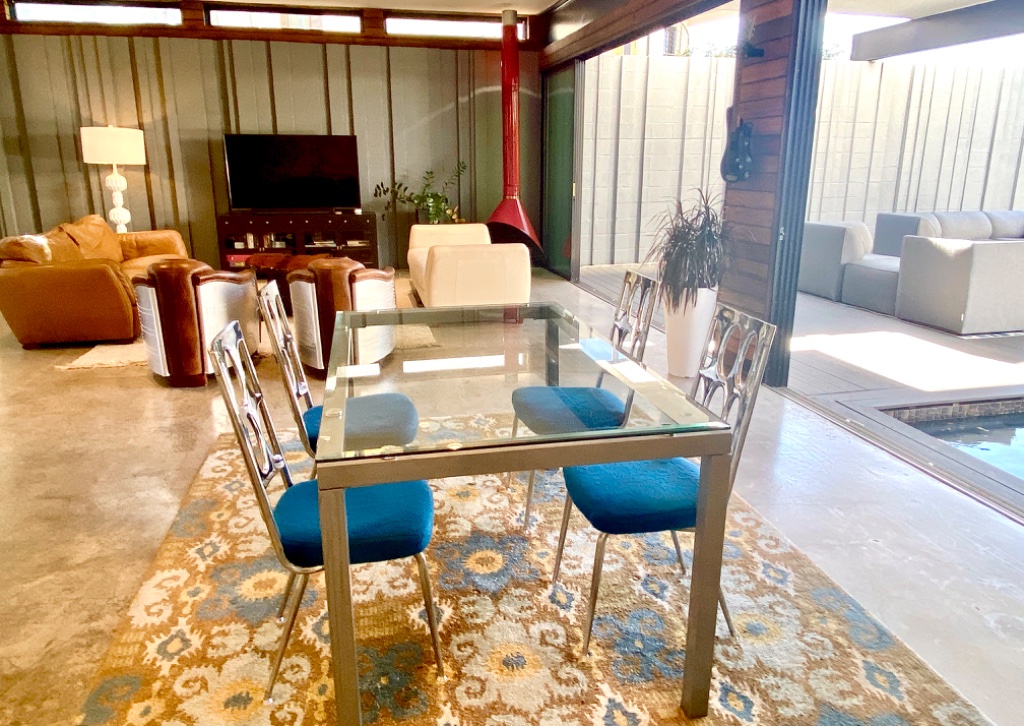 Dining room with gold chairs, pool view, and sputnik chandelier