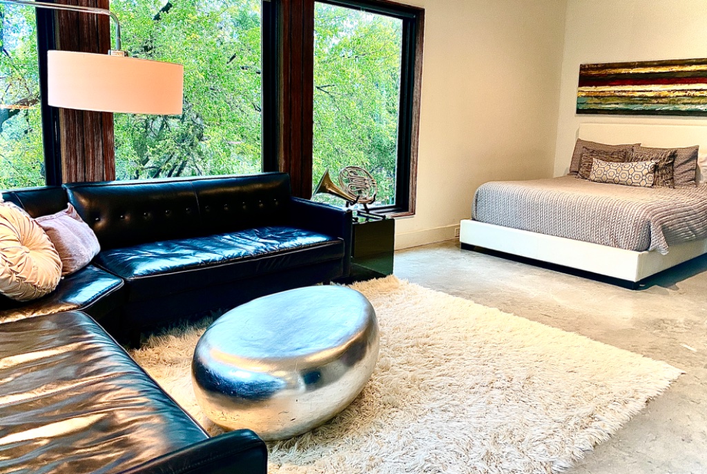 Bedroom suite with leather sofa and treetop views