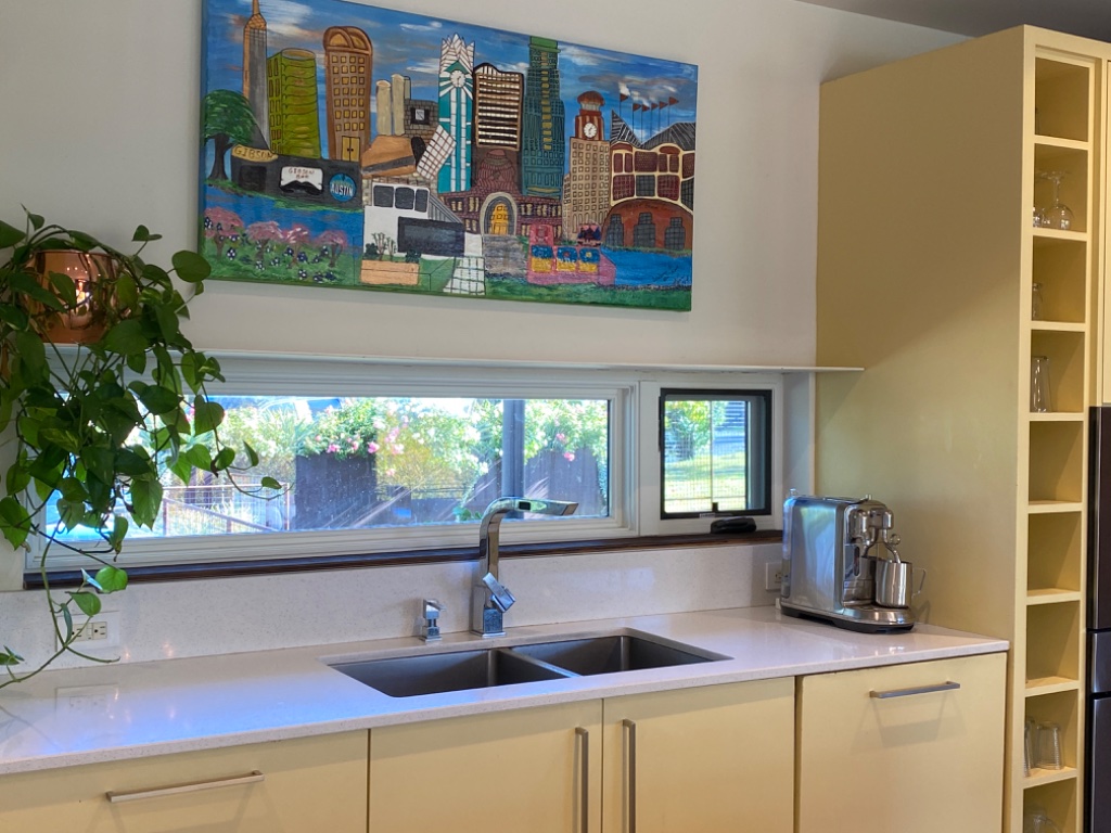 Kitchen island with white bar stools and gas range cooktop