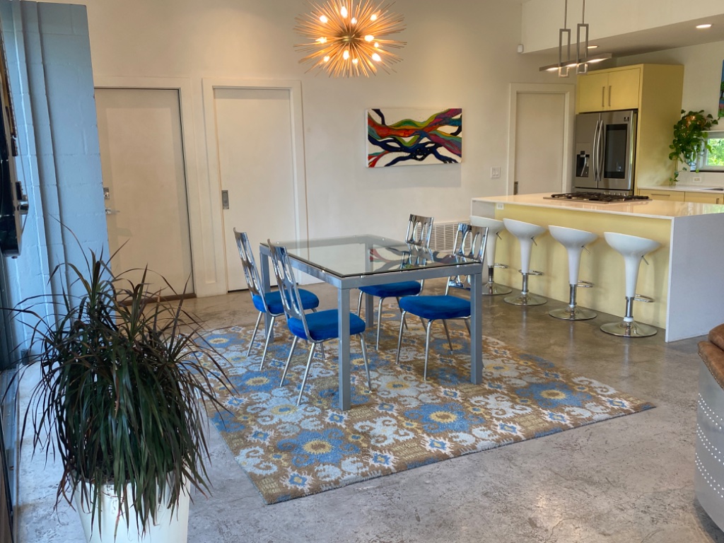 Dining area with sputnik chandelier opening to kitchen and living room