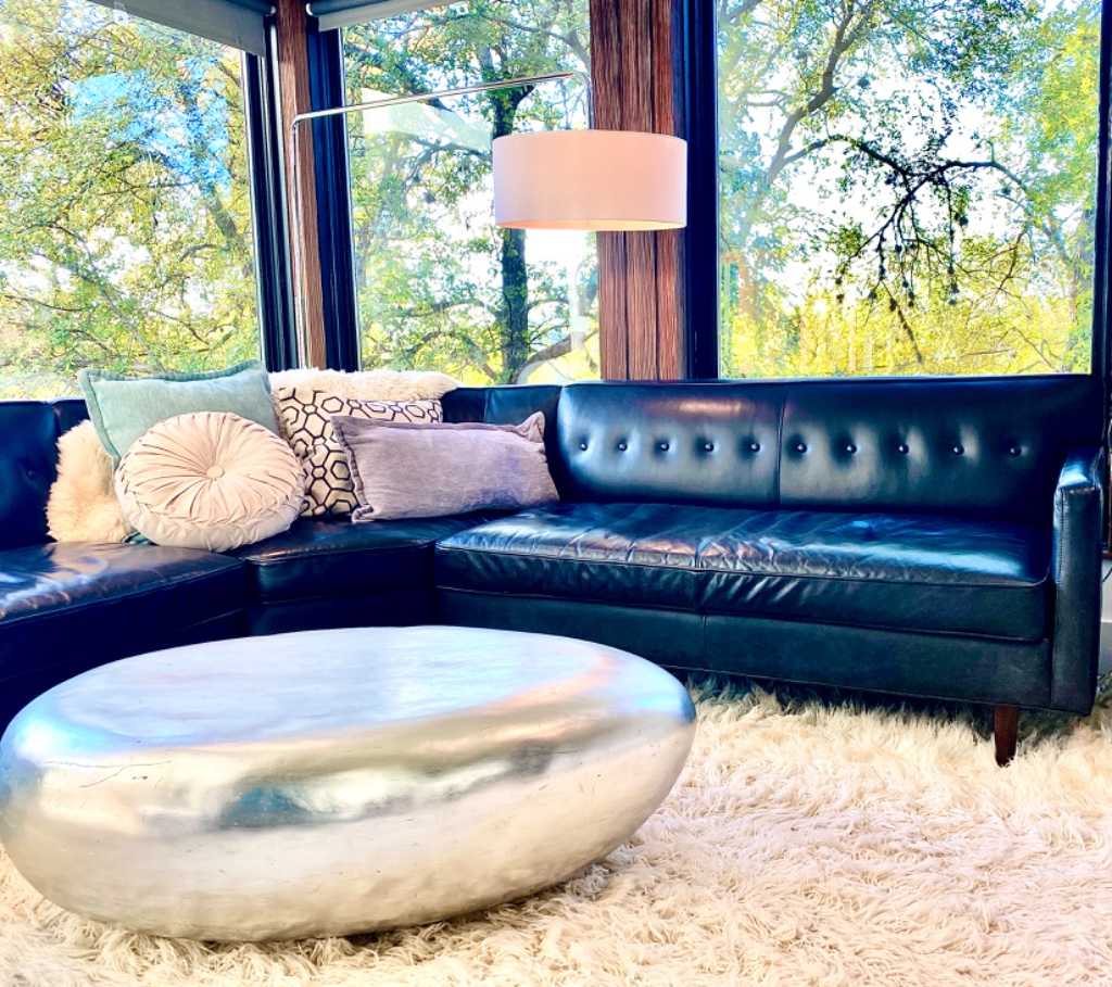 Bedroom lounge with sectional sofa and tree-lined views