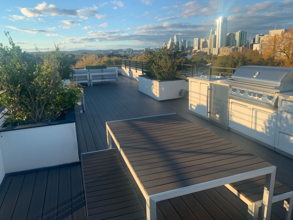 Rooftop outdoor kitchen with grill, sink, and Austin skyline