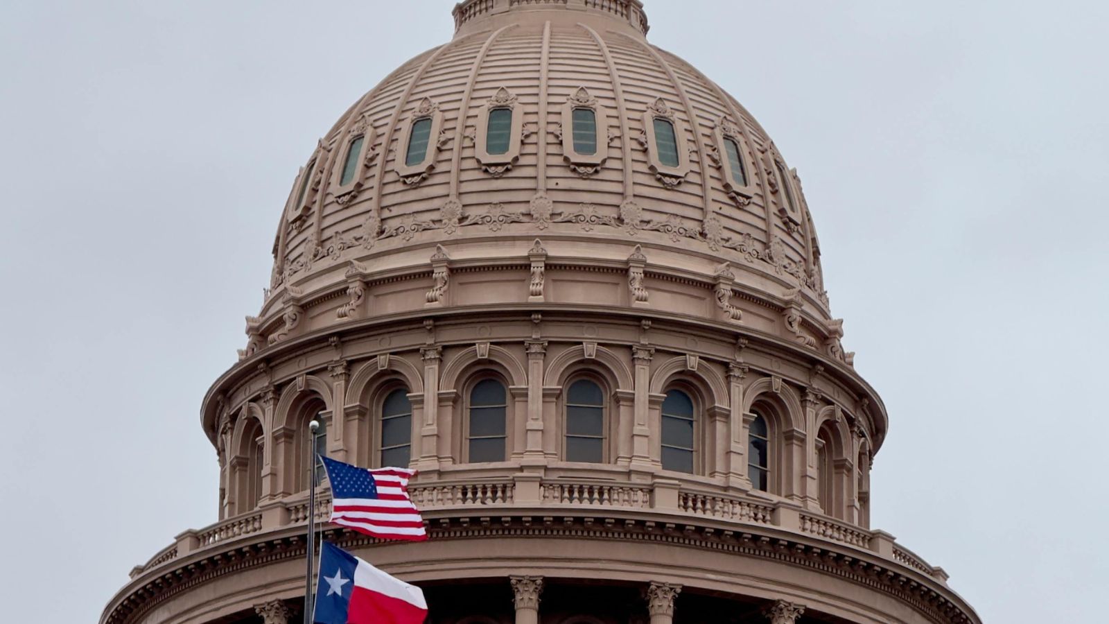 Texas State Capitol dome in Austin with the Texas and United States flags. Photo by Adriana Miller.