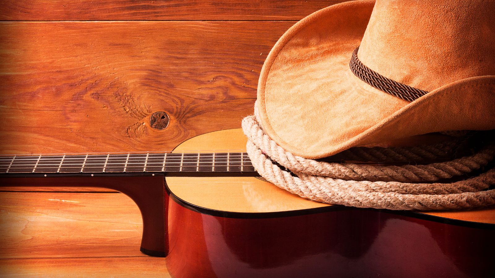 Country music picture with guitar and cowboy hat. Real photograph by LunaticLu / Getty Images Pro, sourced through Canva. Illustrative stock photo; not a photograph of the venues or services reviewed.