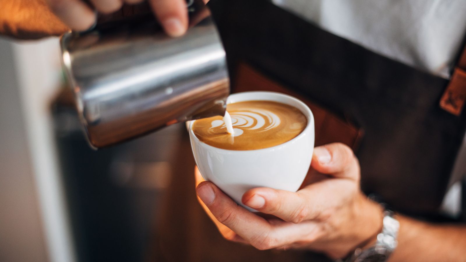 Barista pouring latte art into a white coffee cup. Illustrative photograph by agrobacter / Getty Images Signature, sourced through Canva; not photographed at Better Half.