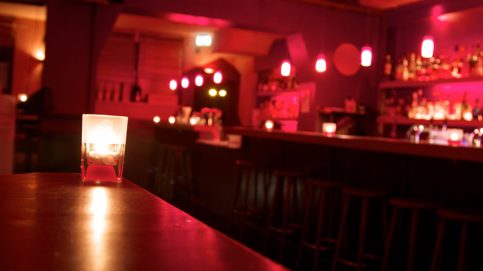 Bar scene with candle. Real photograph by Kohlerphoto / Getty Images Signature, sourced through Canva. Illustrative stock photo; not a photograph of the venues or services reviewed.