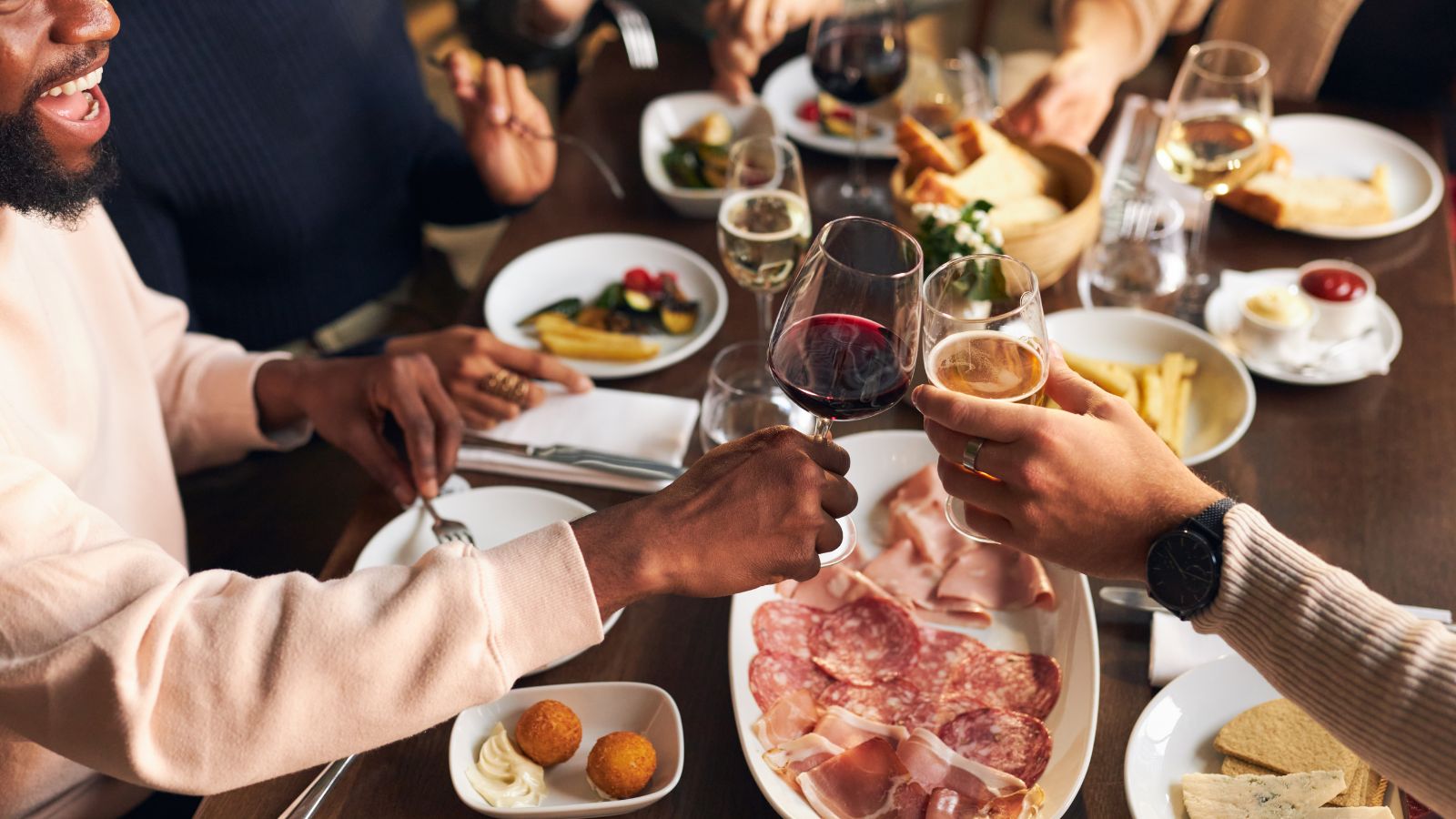 Friends Toasting at Dinner in Restaurant. Real photograph by southworks, sourced through Canva. Illustrative stock photo; not a photograph of the venues or services reviewed.