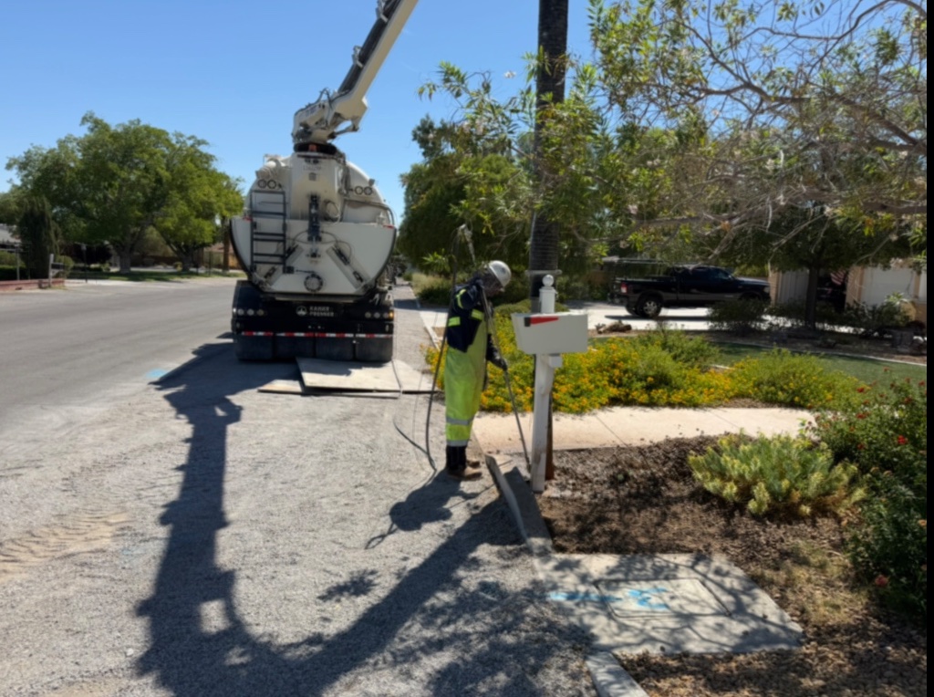 Jetco operator potholing to expose underground utilities on residential street