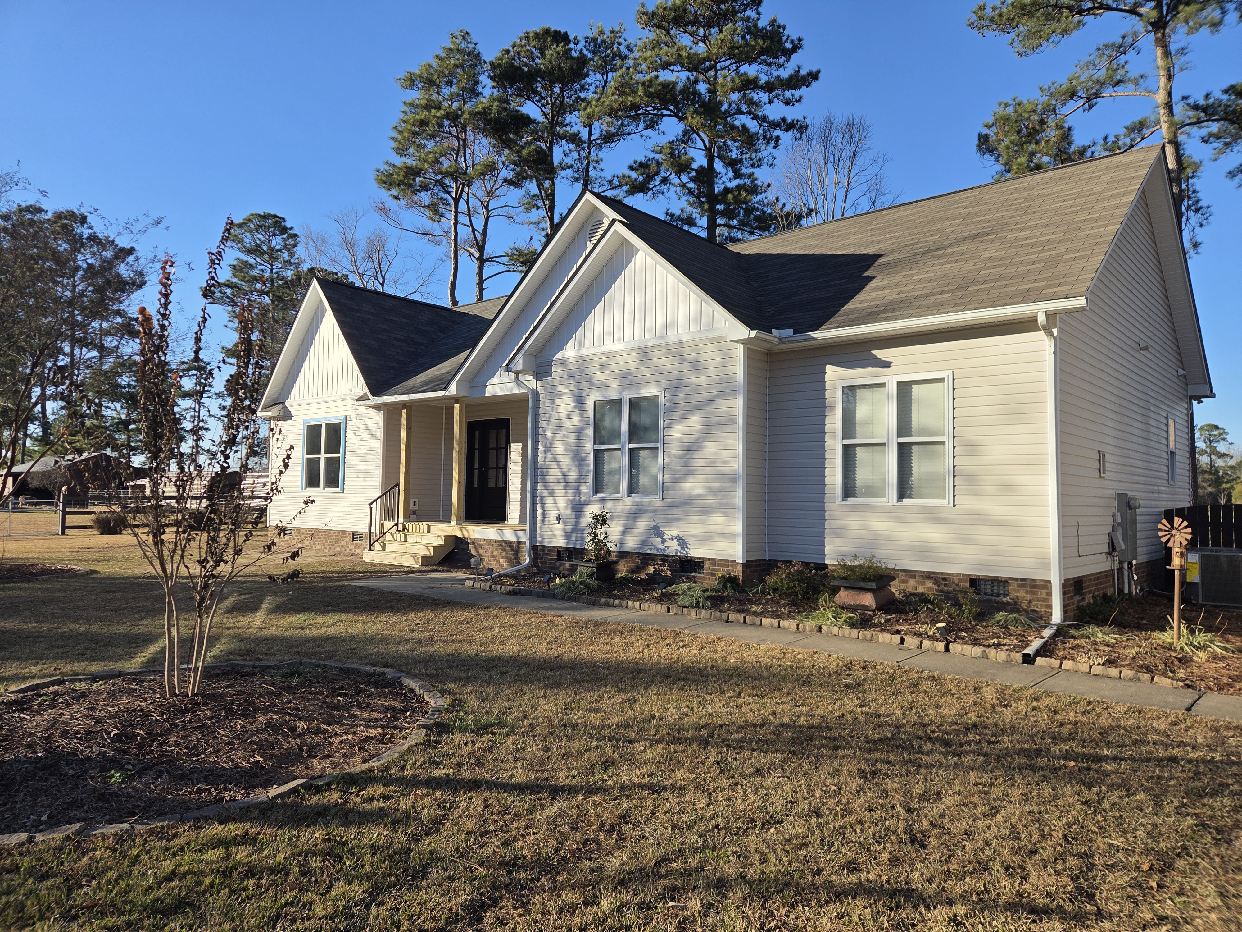 Completed Clayton, NC home addition with matching siding, board-and-batten gable, and new roof