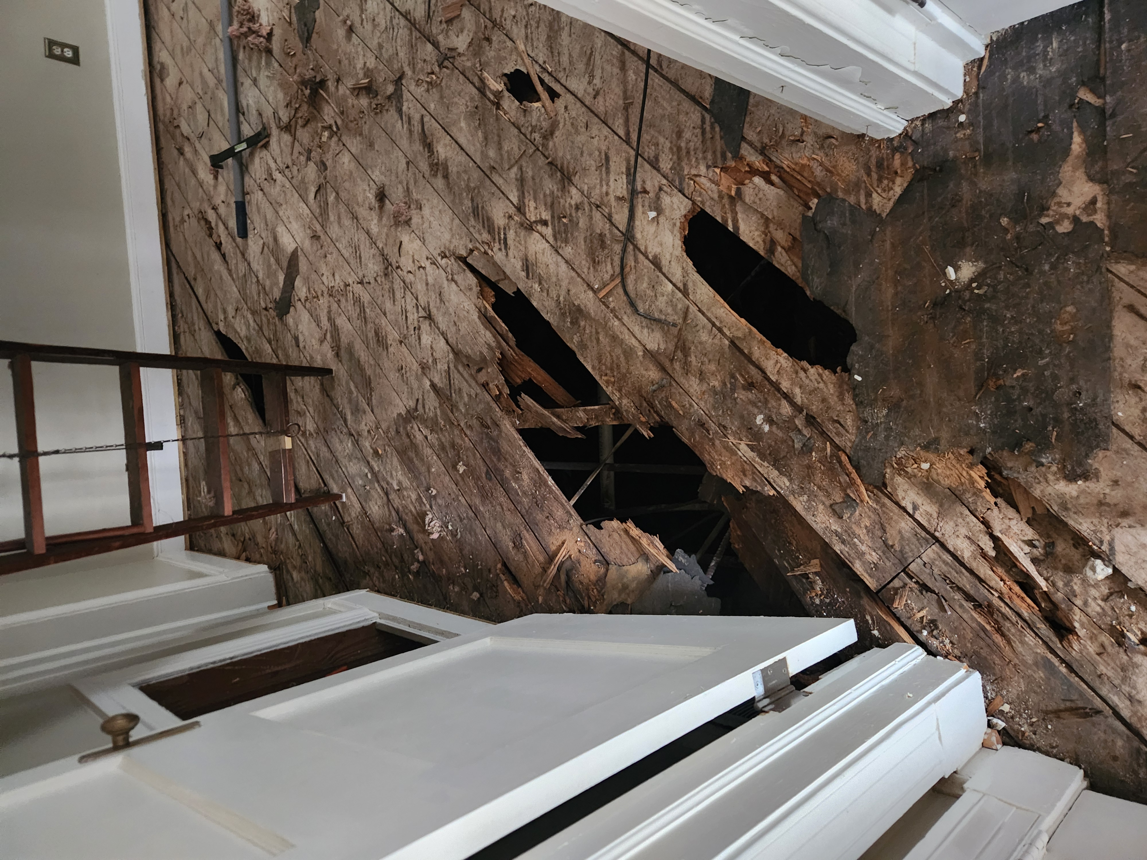 Rotted plank subfloor with holes through to the crawlspace, exposed during the downtown Raleigh remodel demolition