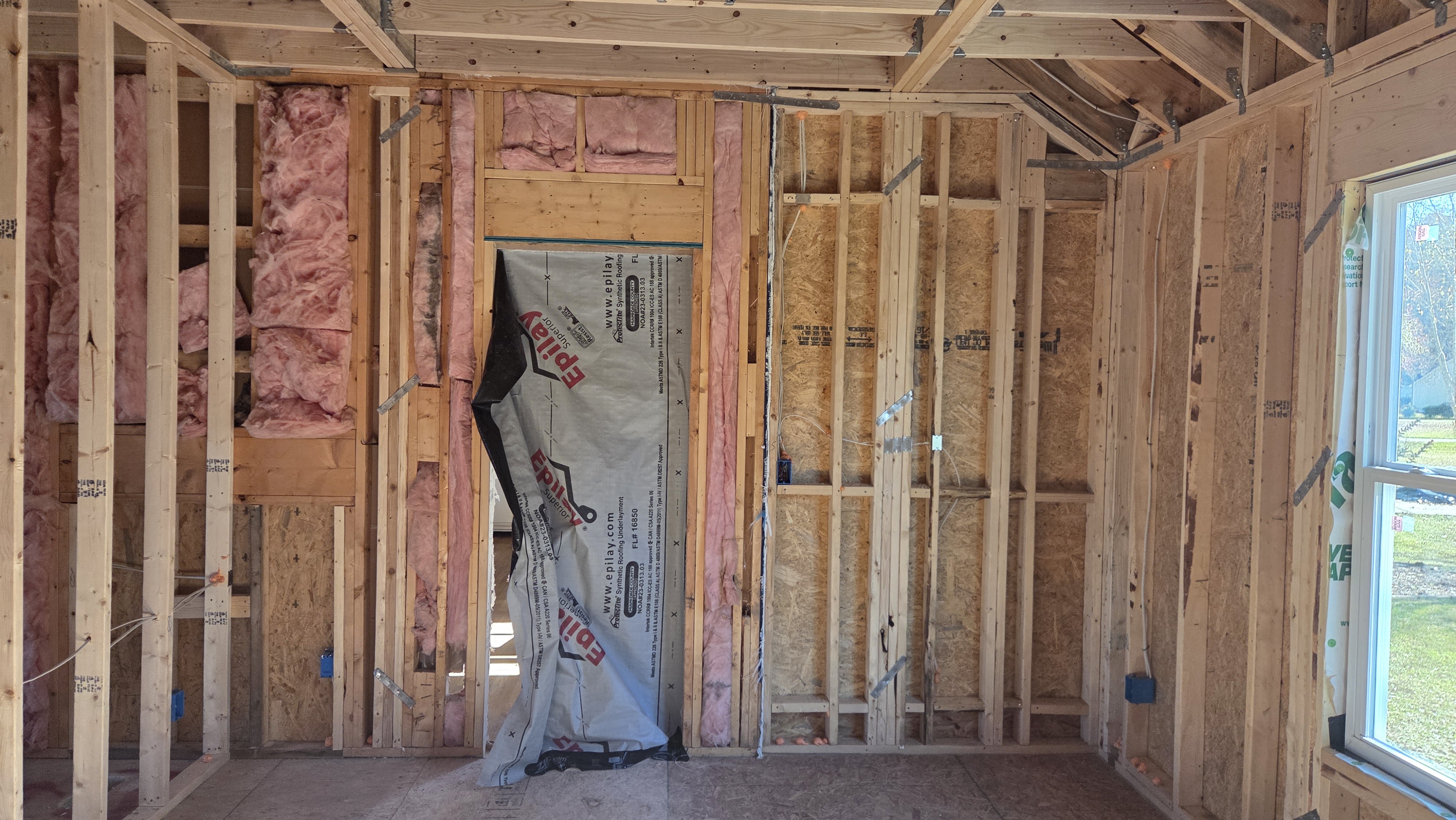 Clayton addition walls with insulation, electrical boxes, and a framed doorway ready for inspection