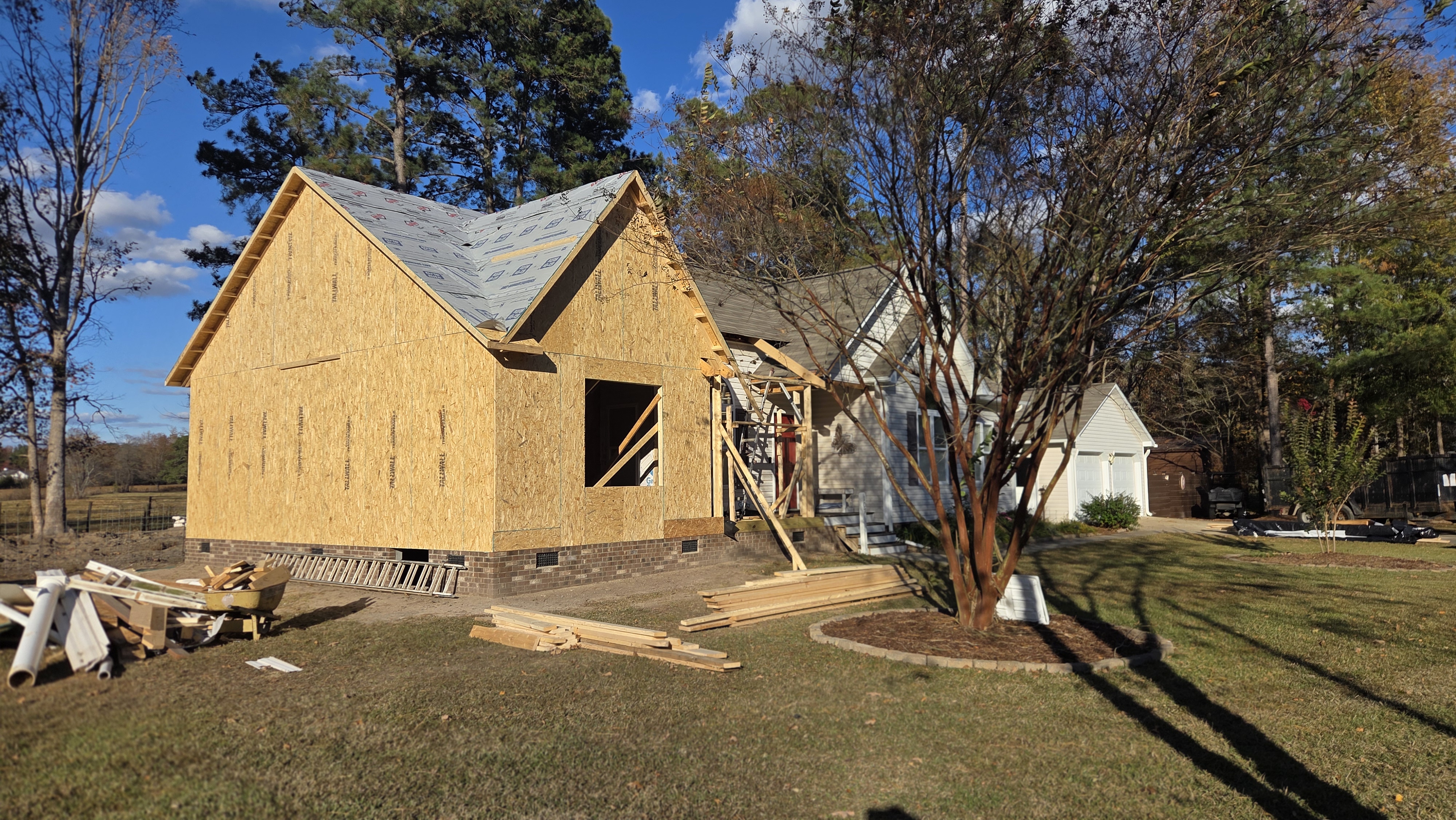New home addition framed and sheathed alongside the original Clayton, NC ranch house