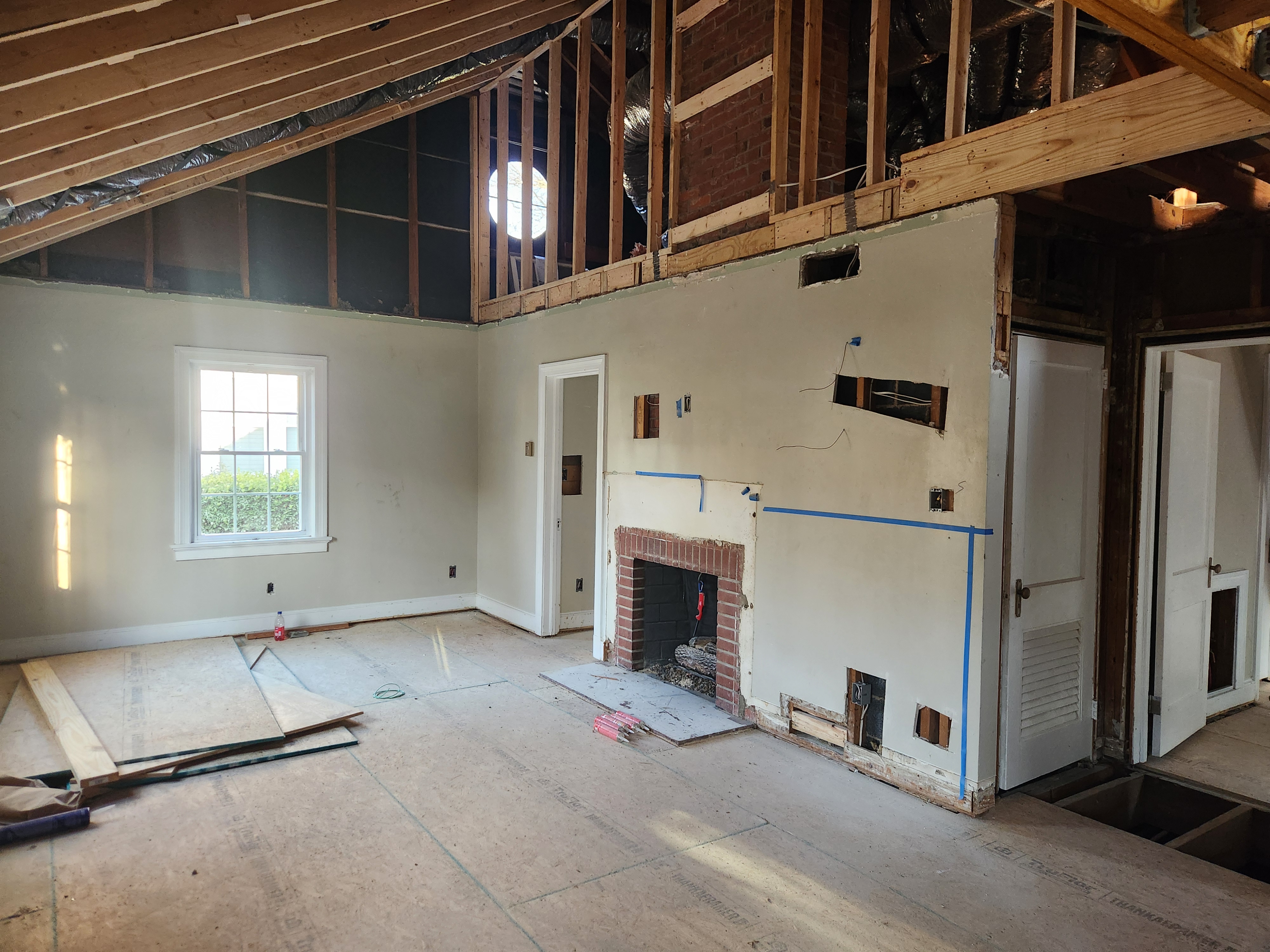 Downtown Raleigh living room with the ceiling opened above the brick fireplace to create the new vault