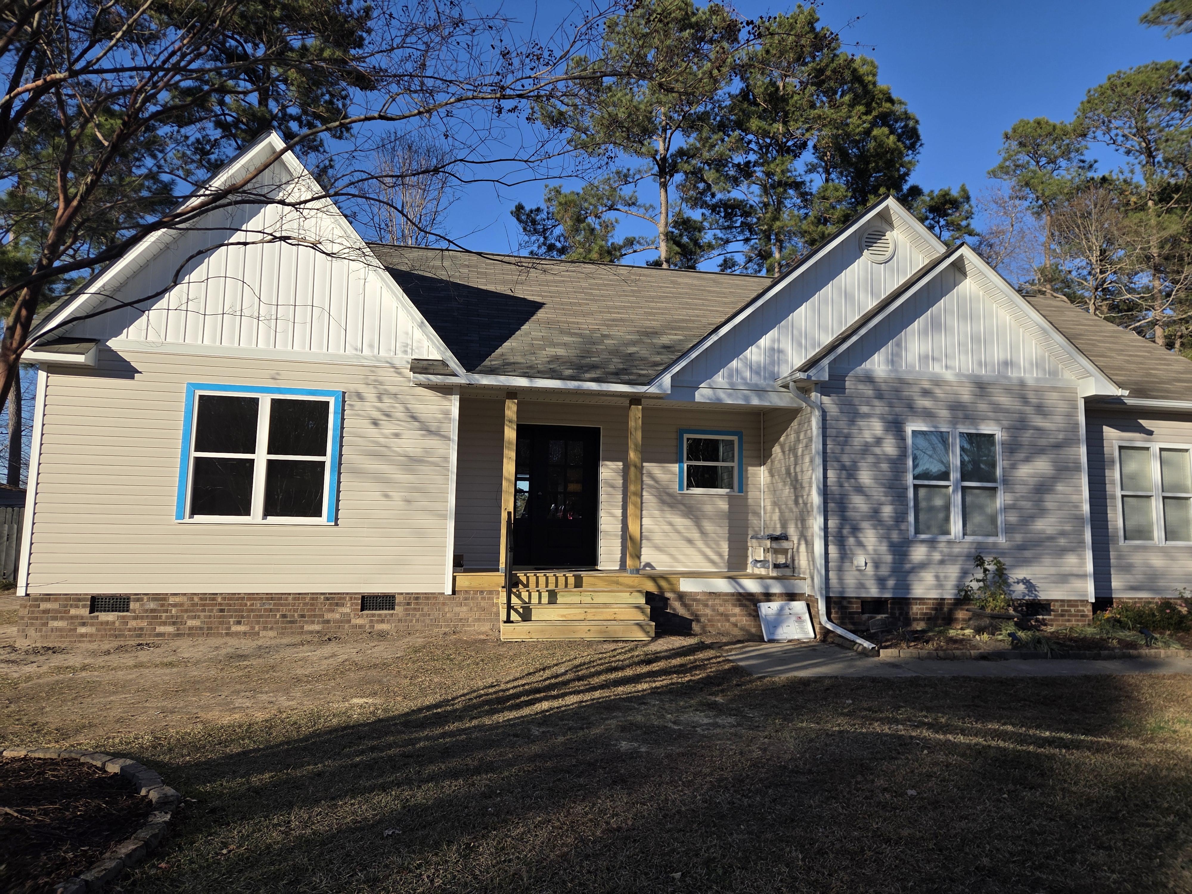 Finished front elevation of the Clayton home addition with new gables, siding, and covered entry
