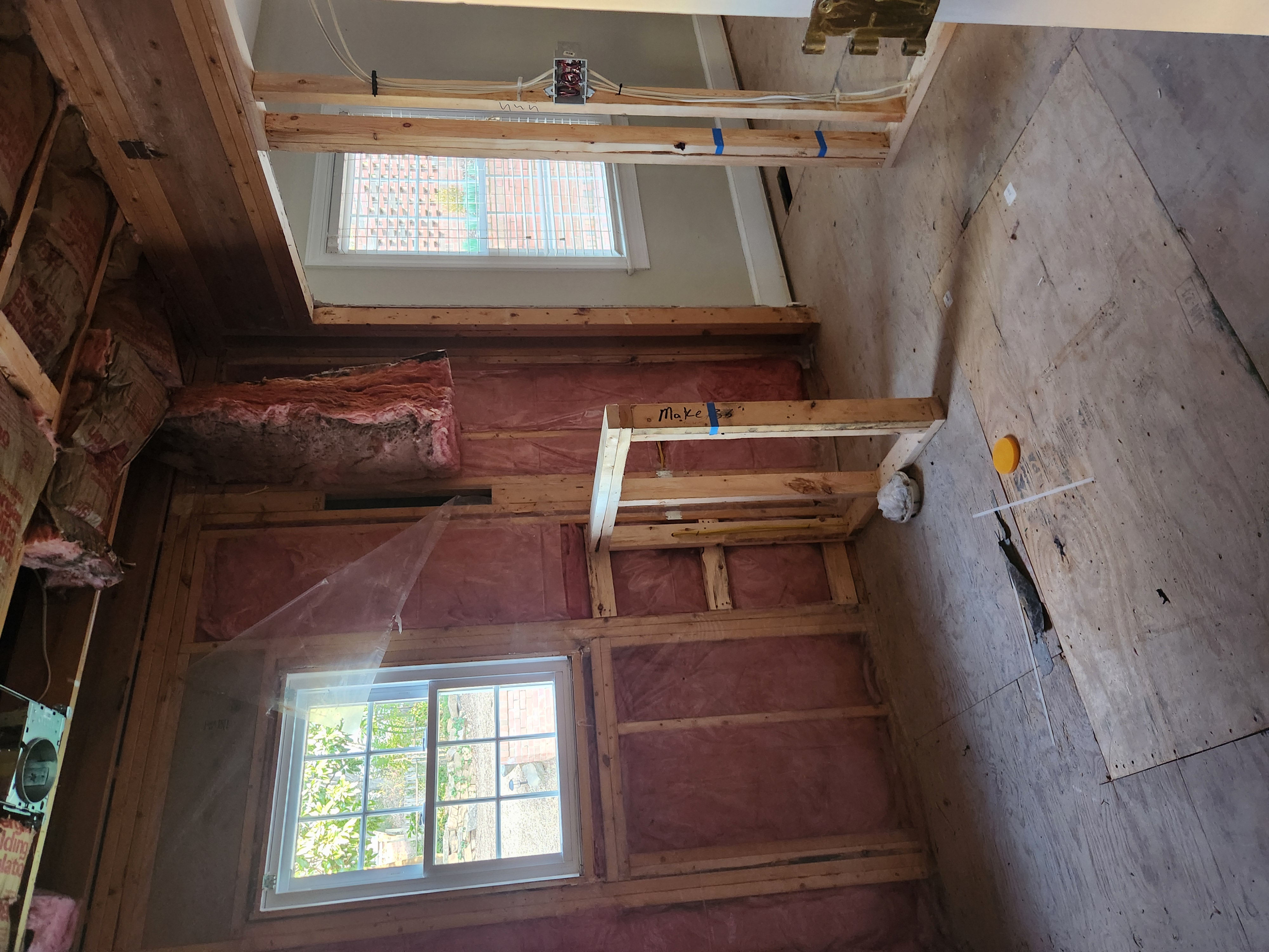 Interior wall stripped to studs and pink insulation with new header framing during the Raleigh remodel