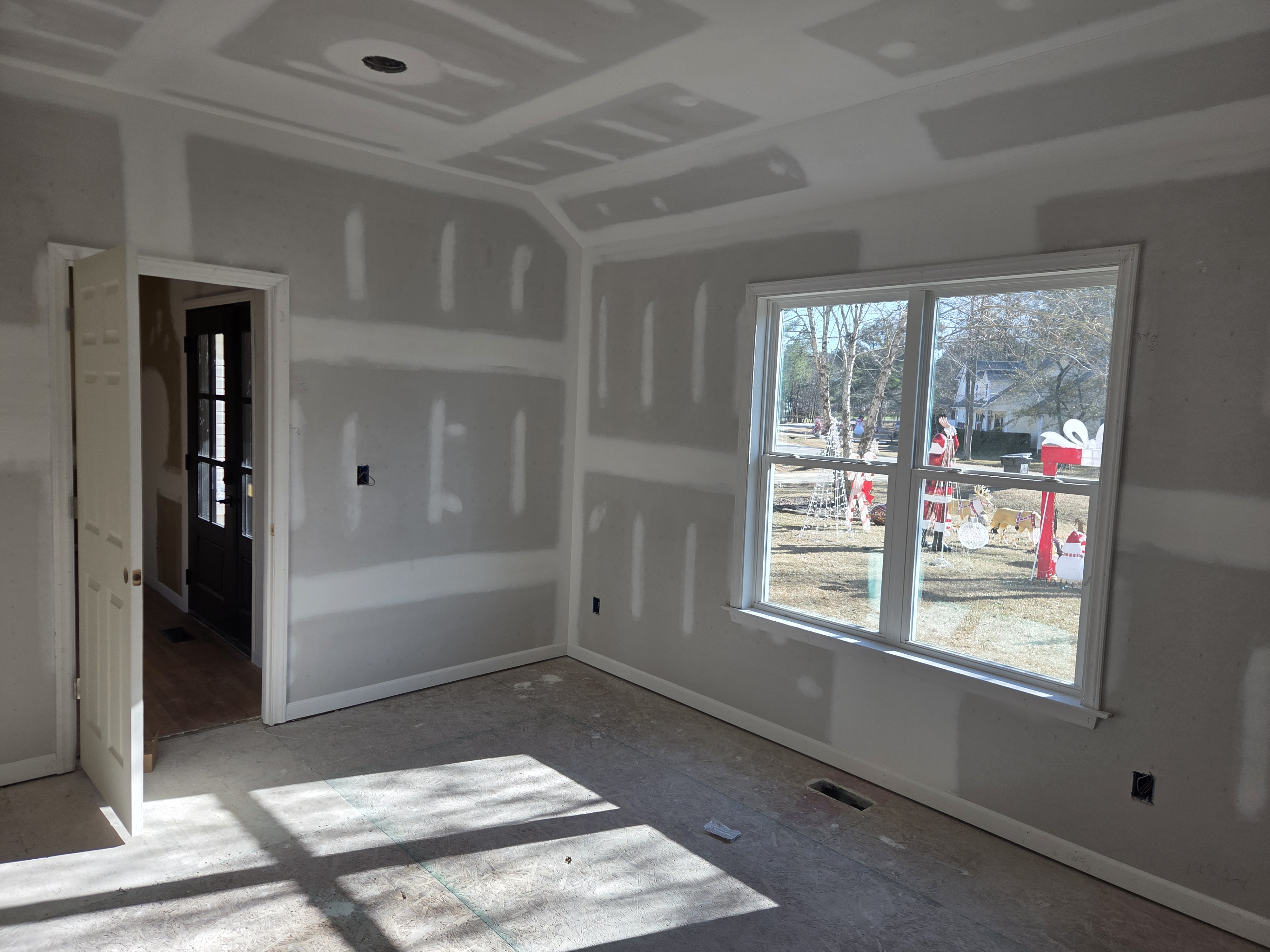 Finished addition room with trimmed window and doorway opening into the original Clayton house