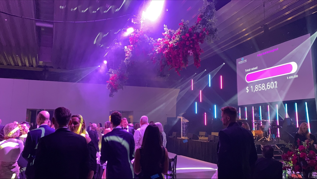 Large event display screen showing live fundraising totaliser at a gala event