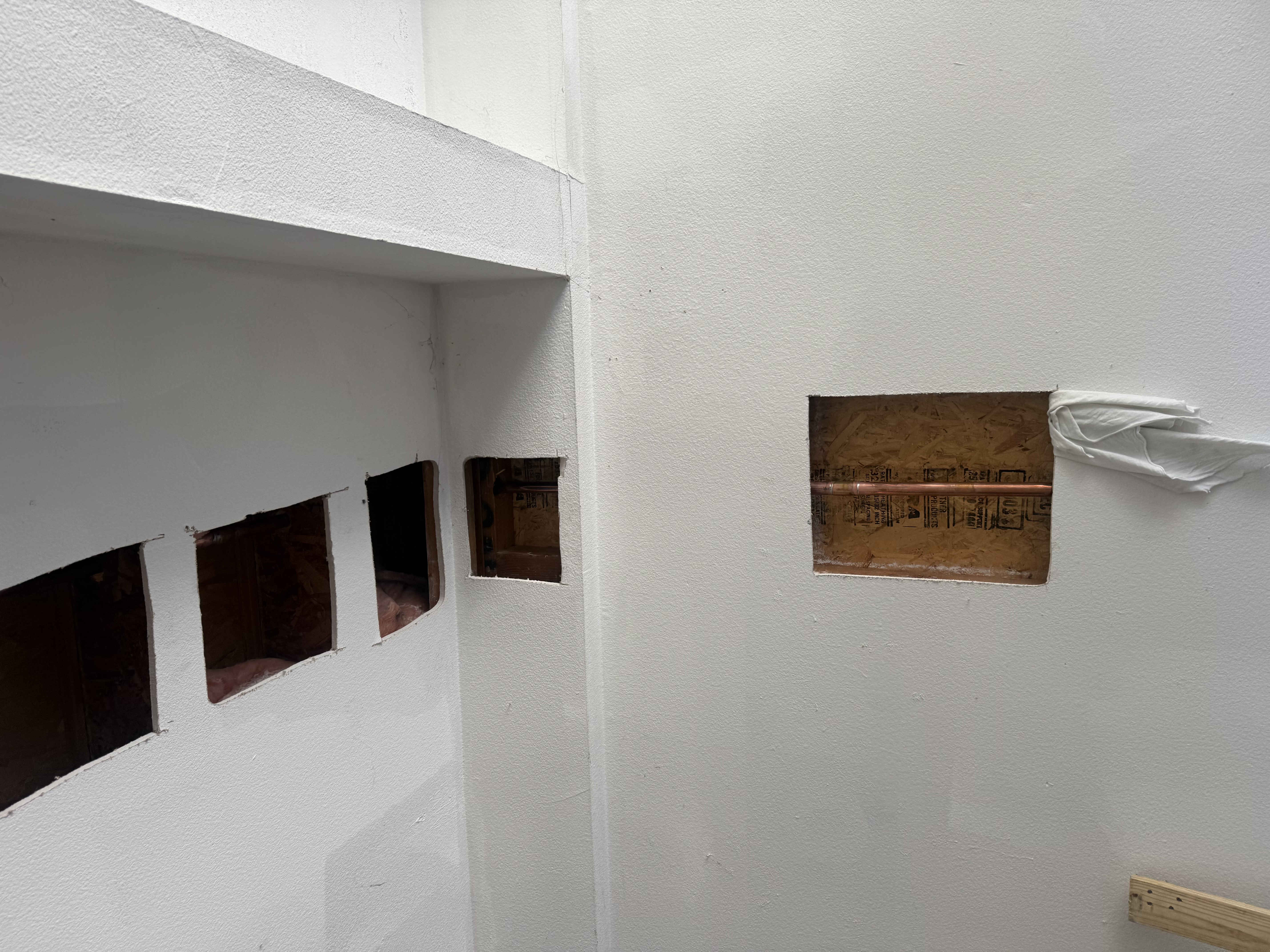 Clean Type L copper pipe run through wall access cutout during repipe installation