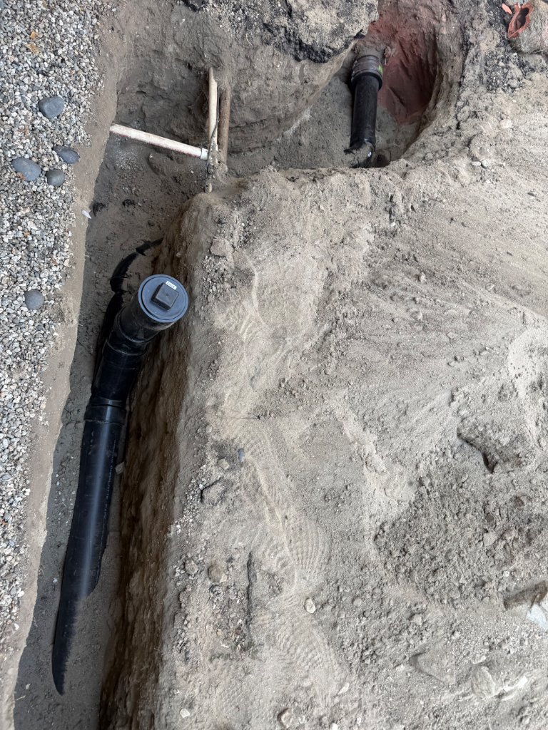 New ABS sewer pipe laid in excavated trench with cleanout cap