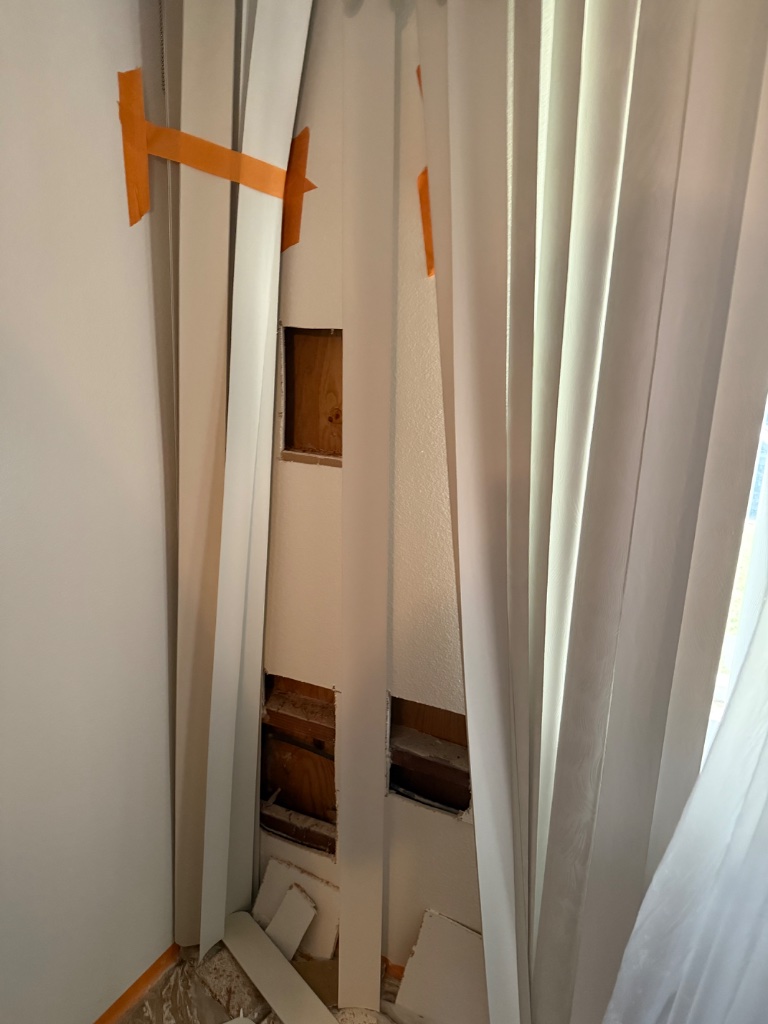 Wall access holes with plastic sheeting barriers protecting adjacent rooms