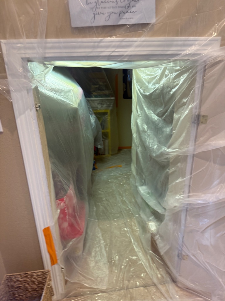 Hallway protected with plastic sheeting — ladder and skylight visible during repipe