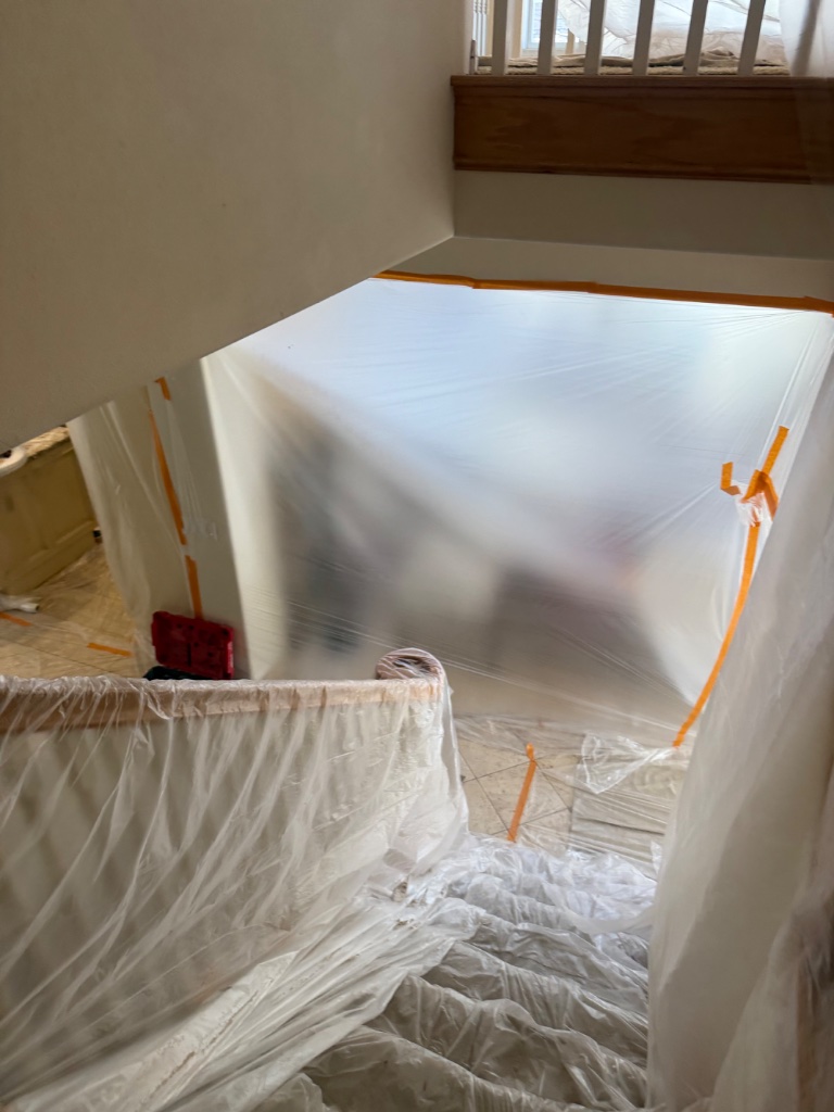 Staircase and entryway sealed with plastic barriers during repipe work