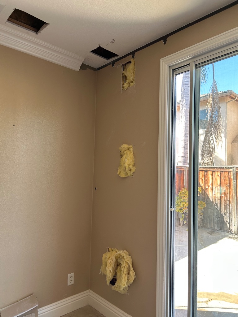Bedroom wall and ceiling access holes cut for pipe routing during repipe