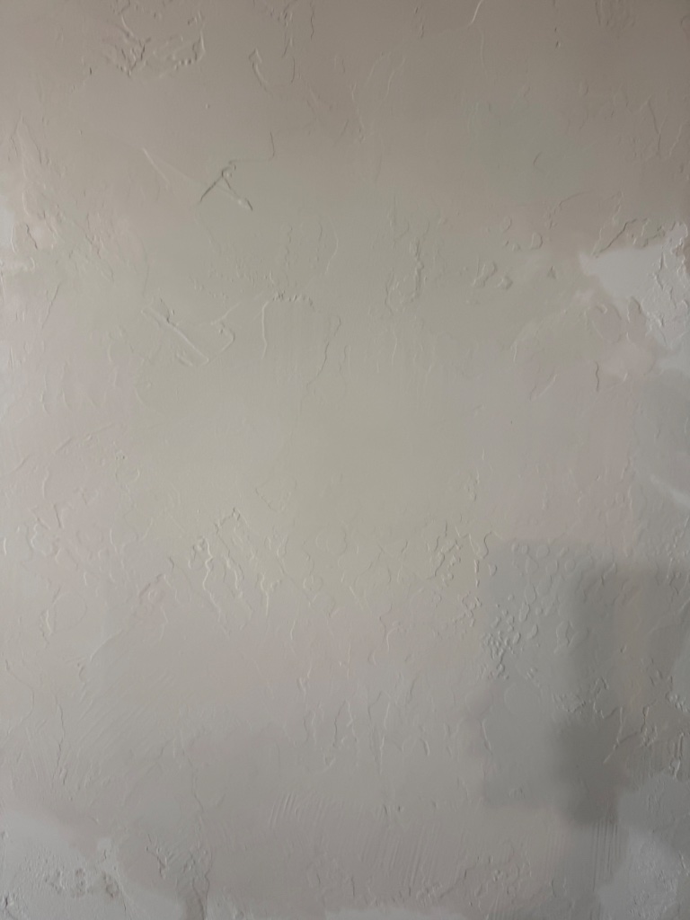 Knockdown wall texture matched seamlessly after repipe patching