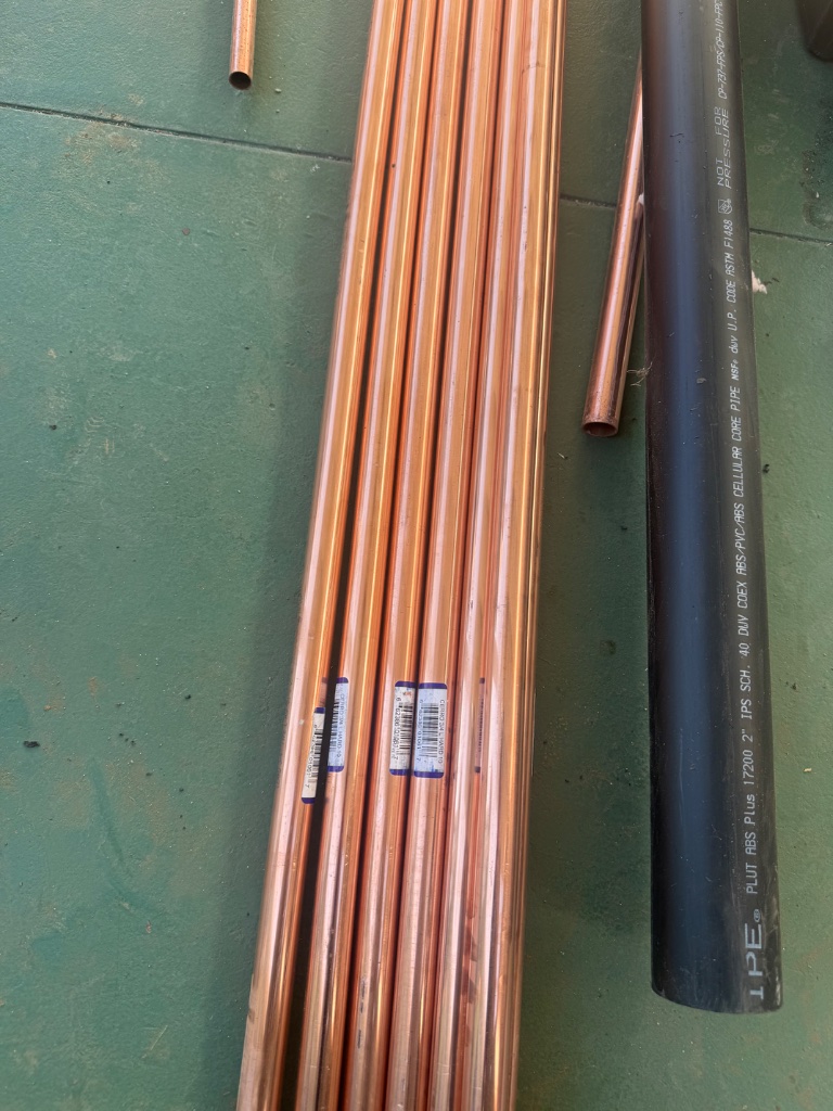 New copper pipe and ABS materials staged and ready for installation