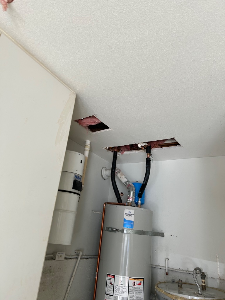 Attic access and ceiling opening showing new copper pipe routing