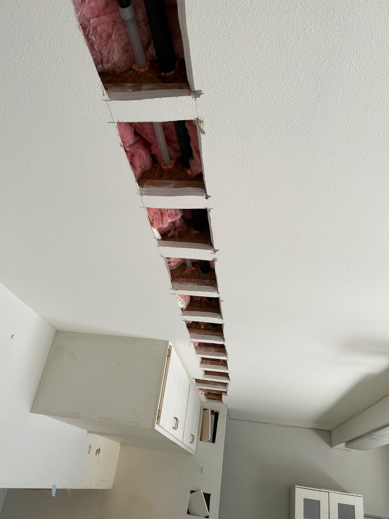 Bathroom rough-in showing new water heater connections and ceiling access