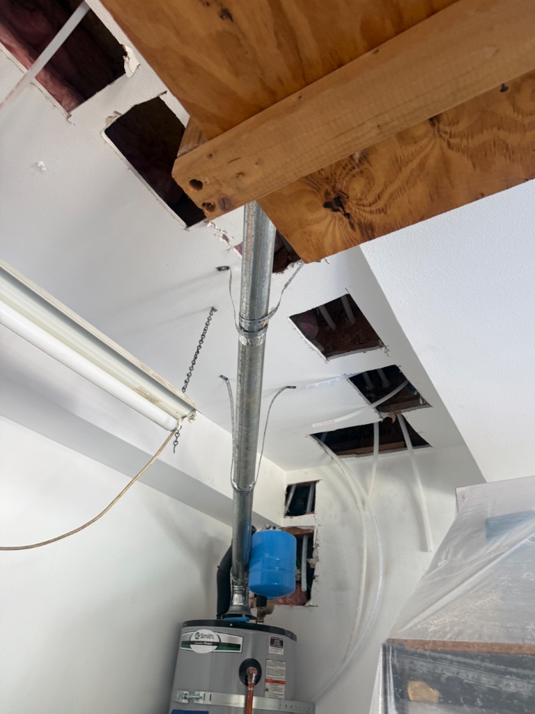 Water heater area with new copper connections and ceiling access holes