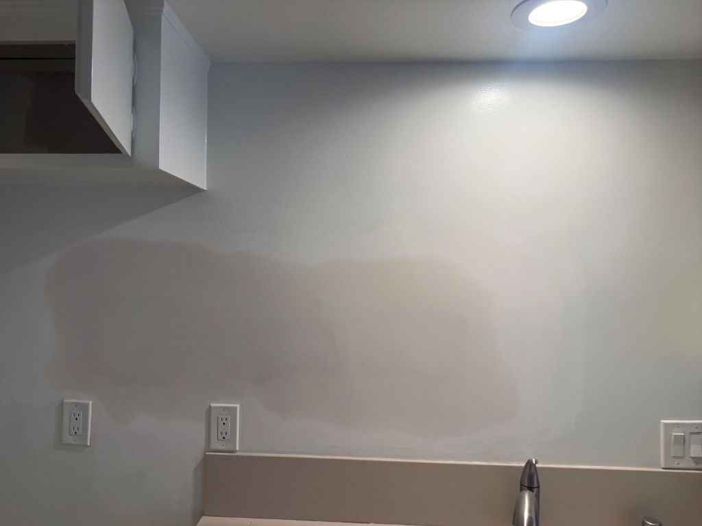 Kitchen wall patched and ready — outlets, switch plates, and faucet access restored