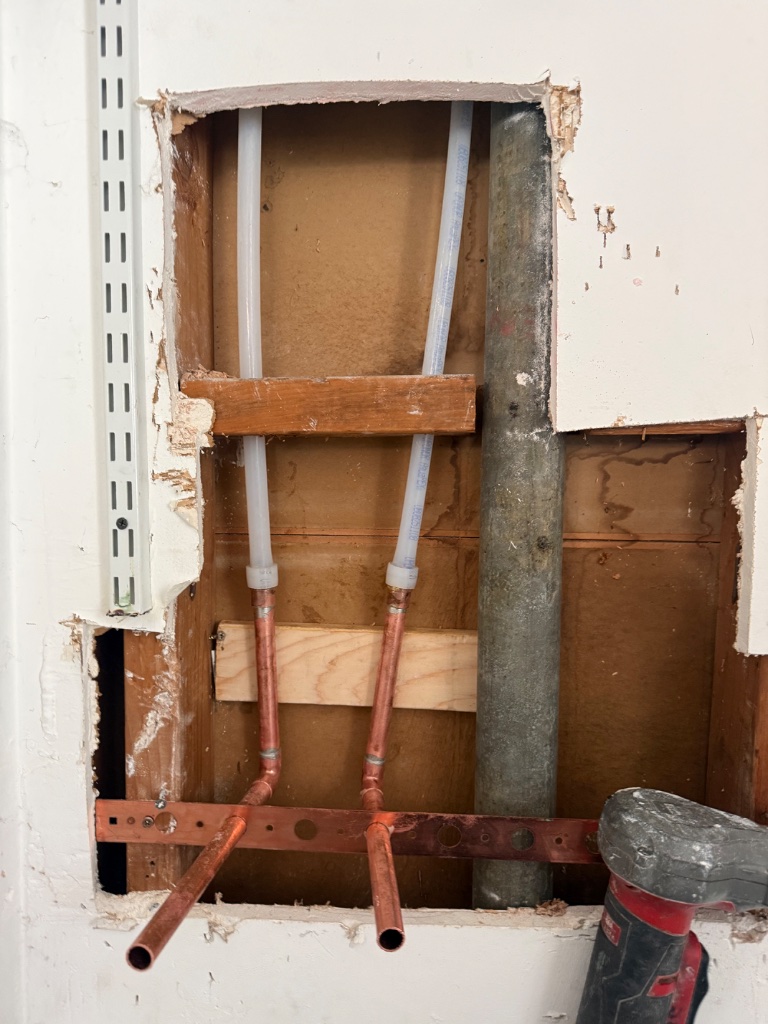 Excavated mainline area — new copper shutoff valve and fittings at meter box