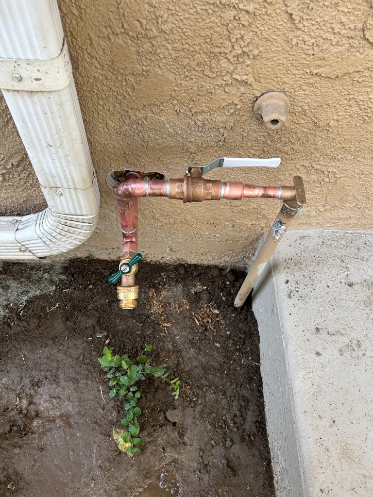 Open wall access showing new copper toilet supply connections to toilet tank
