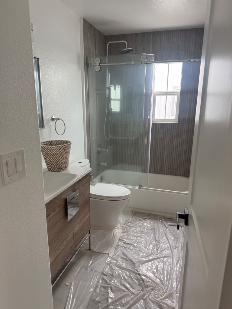 Modern bathroom remodeled after repipe — new shower and fixtures installed
