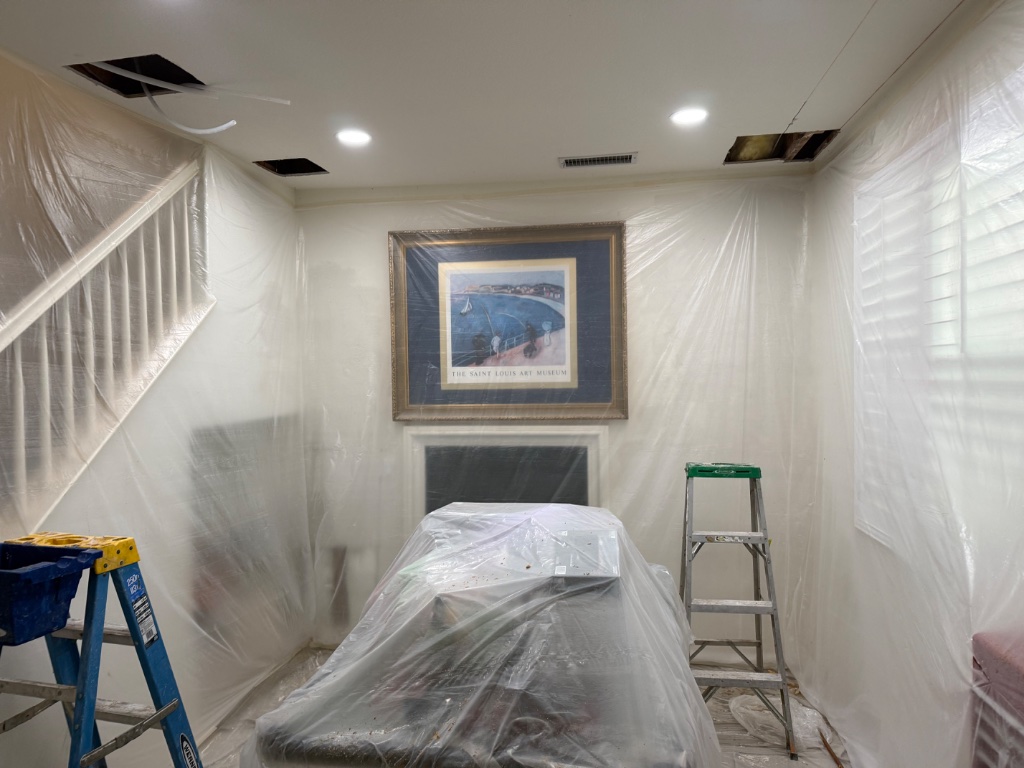 Living room fully covered with walls and furniture protected during repipe