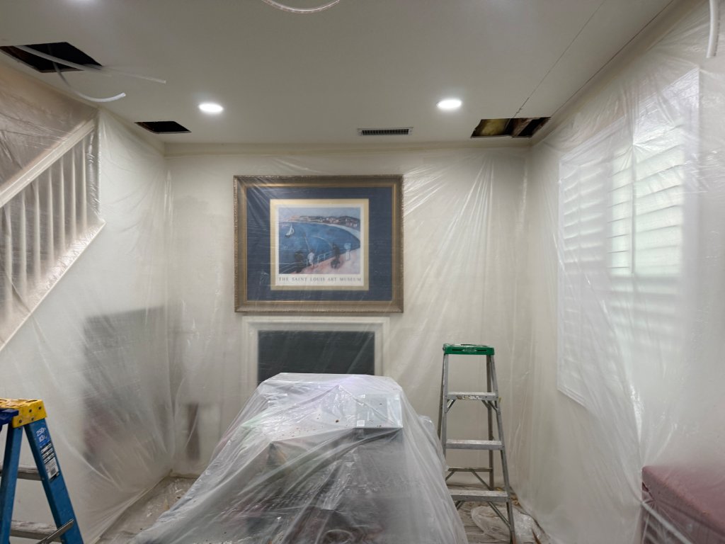 Living room protected with plastic sheeting during a repipe
